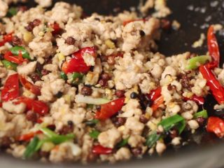 8、干煸豆角,加入干辣椒和花椒炒香。