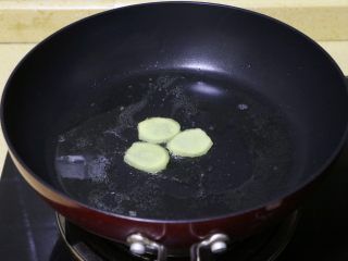 9、糖醋排骨,将剩余的一半姜片放入油锅中爆一下