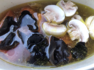 14、西红柿豆腐汤,把西红柿、口蘑、黑木耳都再放入炖锅。