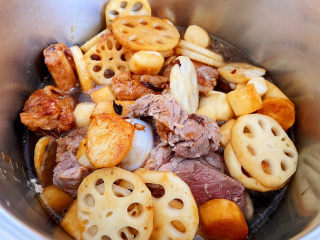 14、筒骨莲藕汤,炒均匀后，把它们全部倒入电压力锅中，加入开水，没过所有材料，然后放大概3勺的盐，把电压力锅调整到排骨的档位开始炖汤。