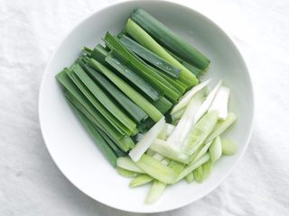 2、川味回锅肉,蒜洗净，蒜白斜刀切，蒜青直刀切；