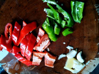 3、让你停不下来的爆炒花甲,青红椒洗干净，去头尾，切小块，蒜头拍扁去皮，姜块去皮切片。