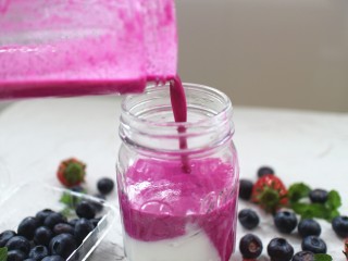 10、火龙果奶昔,打好后，我们开始来装饰它，首先在杯子底部倒入一层原味酸奶，然后再将火龙果奶昔全部倒入！