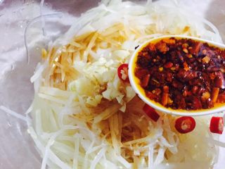 8、#绿色美食#炝拌香辣土豆丝,加入一勺自制辣椒红油，这里简单分享一下：把葱段炸出香味后，倒入辣椒粉中，分次倒入即可！