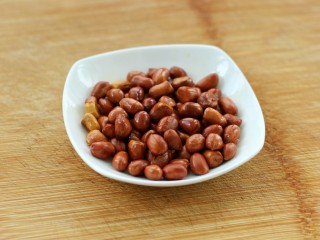 3、菠菜陈醋花生米,待表皮稍微变色后盛入盘中晾凉备用
