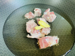 4、冬瓜薏米排骨汤,锅中加入清水放入排骨、姜片、一勺料酒