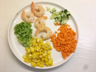7、凤尾虾饭团,将胡萝卜、黄瓜切成丁，玉米剥粒，西兰花切碎