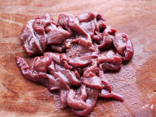 2、生滚槐花猪肝粥,猪肝用刀切成薄片。