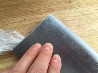 4、香煎土豆饼,用刀压下去。压时依旧收紧收口。（我这里一只手忙着拍照了！）最好一手扭紧保鲜袋，一边用刀压下去