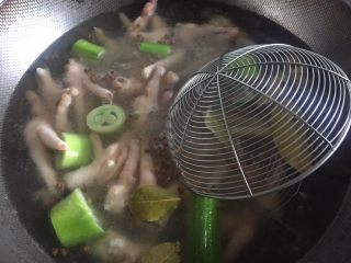 3、酸辣鸡脚,锅里水烧开放入鸡脚，京葱，生姜，花椒，香叶。