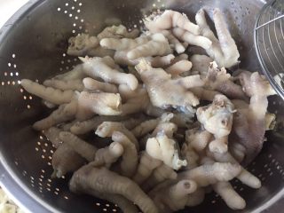 6、酸辣鸡脚,在冷开水里把鸡脚洗干净，放进沥水篮控干水份。