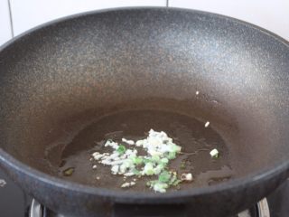 8、番茄金针菇肥牛卷,热锅凉油,放入葱花和蒜片,炒出香味。