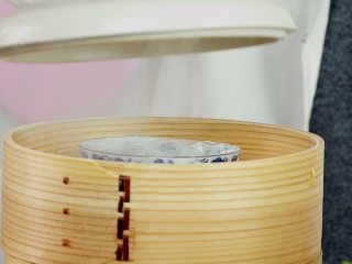 5、顺德双皮奶,将牛奶蛋清混合液倒回到有奶皮的碗里，盖上保鲜膜，放入蒸锅中，大火蒸约10分钟