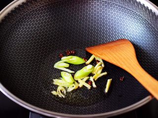 6、丝瓜花蛤炖豆腐,另起锅烧热，倒入花生油烧至六成热时，小火慢慢炸香花椒后，大火爆香葱姜丝。