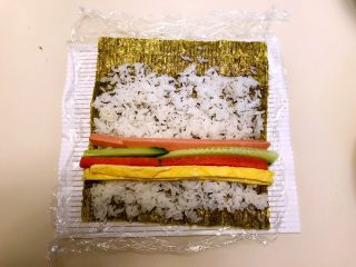 16、寿司,在米饭上加入蛋皮,胡萝卜条,瓜条,火腿条