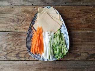 4、京酱肉丝,豆腐皮切方块，胡萝卜，黄瓜，葱白洗净去皮切细丝，也可以根据自己喜好准备其它青菜。