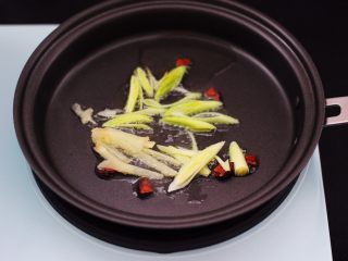 4、虾滑番茄豆干汤,东菱早餐机的平底锅烧热后，倒入花生油烧热后，先小火慢慢炸香八角后，再爆香蒜苗和姜丝。