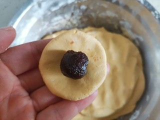 8、南瓜汤圆,揪一块面团压成饼状,包入豆沙馅
