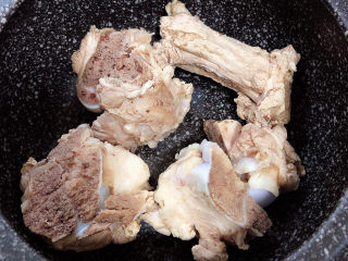 7、酸菜炖大骨,将骨棒放入砂锅中。