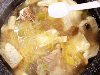 15、酸菜炖大骨,放入两勺盐。