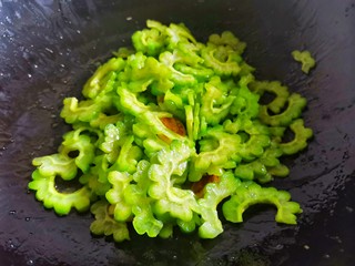 8、苦瓜炒蛋,加入苦瓜炒至变色。