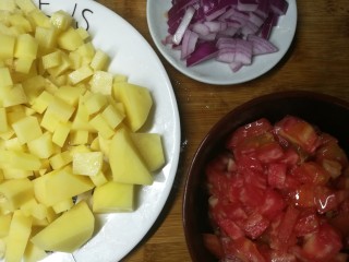 2、四季都宜的西红柿土豆浓汤,西红柿切小丁,土豆也切小丁(我切了几块大的,是为了怕小丁炖化了,特意留几块大的拍照用。事实上都切小,比较容易煮)洋葱也切丁
