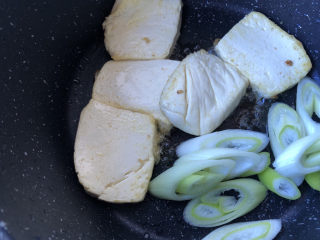 9、蘑菇炖豆腐,豆腐差不多煎好后，下入葱段略煎一下出香味即可。