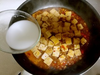 13、红烧豆腐,然后把生粉水倒入锅中，锅铲背轻推，让豆腐完全的混合均匀，芡汁收干一些。