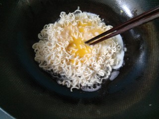 10、#咸味#泡面卧俩蛋（泡面另类吃法）,用筷子，轻轻戳破鸡蛋，使它包裹着泡面。