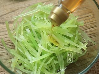 7、夏天小菜~凉拌莴笋,把水倒掉沥干后倒入少许香油;