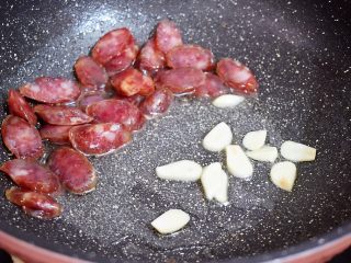 6、西兰花炒腊肠,把腊肠推到一边，放入蒜片炒出香味