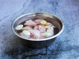 3、腌笃鲜（猪蹄版）,放在温水里浸泡30分钟，然后清洗干净，清洗时用手挤一挤血水。