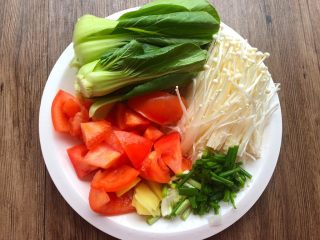 4、豆腐杂烩汤,把西红柿洗干净切成小块；再把上海青叶子剥下来清洗干净；金针菇切掉根部，清洗干净；生姜去皮洗干净切成姜片；葱清洗干净切葱段。