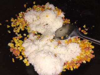 10、火腿丁炒饭,加入白米饭，用锅铲将饭压扁后炒散均匀