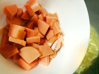 11、鲜香浓郁的菌菇豆腐汤,然后倒入火腿肠片。