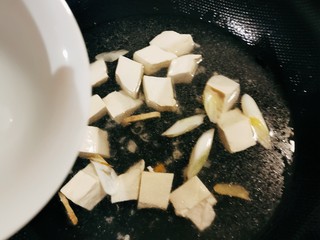 9、金针菇豆腐汤,放入豆腐加热1分钟，倒入适量清水，煮开。
