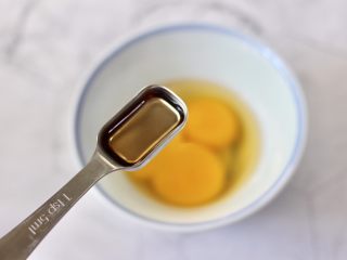 4、海鲜菇鸡蛋汤,鸡蛋打散在碗里,加入料酒调味搅打均匀。