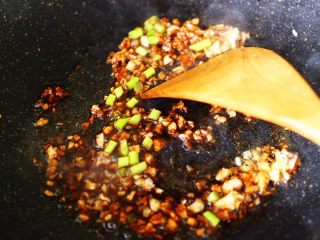 7、番茄香干烩丝瓜,加入一半切碎的蒜苔丁，大火翻炒均匀后。