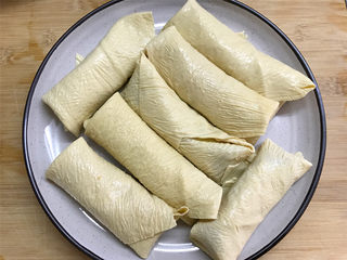 6、豆腐皮包肉,然后把豆腐皮包起来，全部做好后码入盘子中。