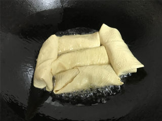 7、豆腐皮包肉,锅中倒入适量油，放入包了馅的豆腐皮卷。