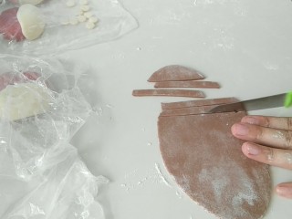 11、花样馒头之愤怒的小鸟,取黑色面团，如图，做出条状的眉毛。