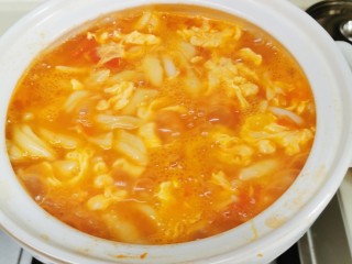 10、香浓蕃茄面汤,关小火，慢慢地把剩下的鸡蛋液浇进去，勺子轻轻推动一下，这样子煮蛋花又滑又漂亮！