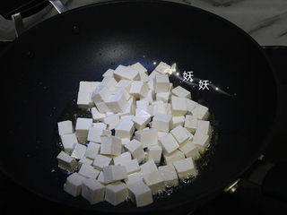 3、孜然小葱煎豆腐,油锅烧热，下豆腐块煎。丢下去就可以了，不用来回翻动，豆腐嫩，容易碎。