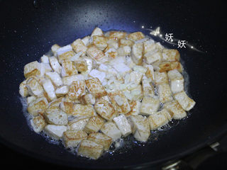 6、孜然小葱煎豆腐,撒入大蒜提香。