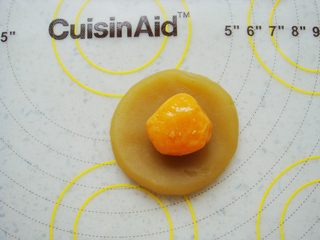 8、莲蓉蛋黄冰皮月饼,莲蓉馅在手心里按扁放入一个蛋黄。