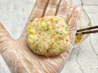 10、鸡胸蔬菜饼,手带一次性手套，抺少许的油防粘，取一团放入掌心，将其压扁成饼状