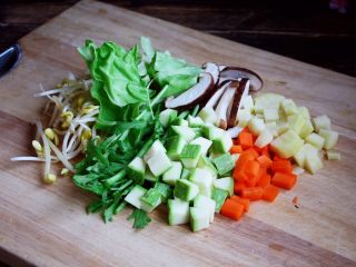 13、十味  海鲜（白蚬子）豆腐大酱汤,将黄豆芽清洗干净，圆白菜撕成块，泡发好的木耳撕成小朵，茼蒿切成段，香菇切成片，土豆和胡萝卜及小西葫切成丁。