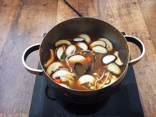 15、十味  海鲜（白蚬子）豆腐大酱汤,将汤料大火煮开，先放入不容易熟的蔬菜，比如黄豆芽、胡萝卜、土豆、香菇、木耳，将这些食材煮至七成熟。