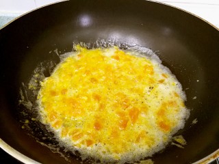 8、蟹黄豆腐南瓜羹,炒锅热油，倒入咸蛋黄不停翻炒，一些比较大的颗粒用铲子碾压一下。