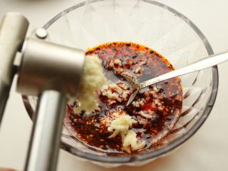 7、香辣口水鸡,蒜用压蒜器压成蒜蓉，放入红油内，